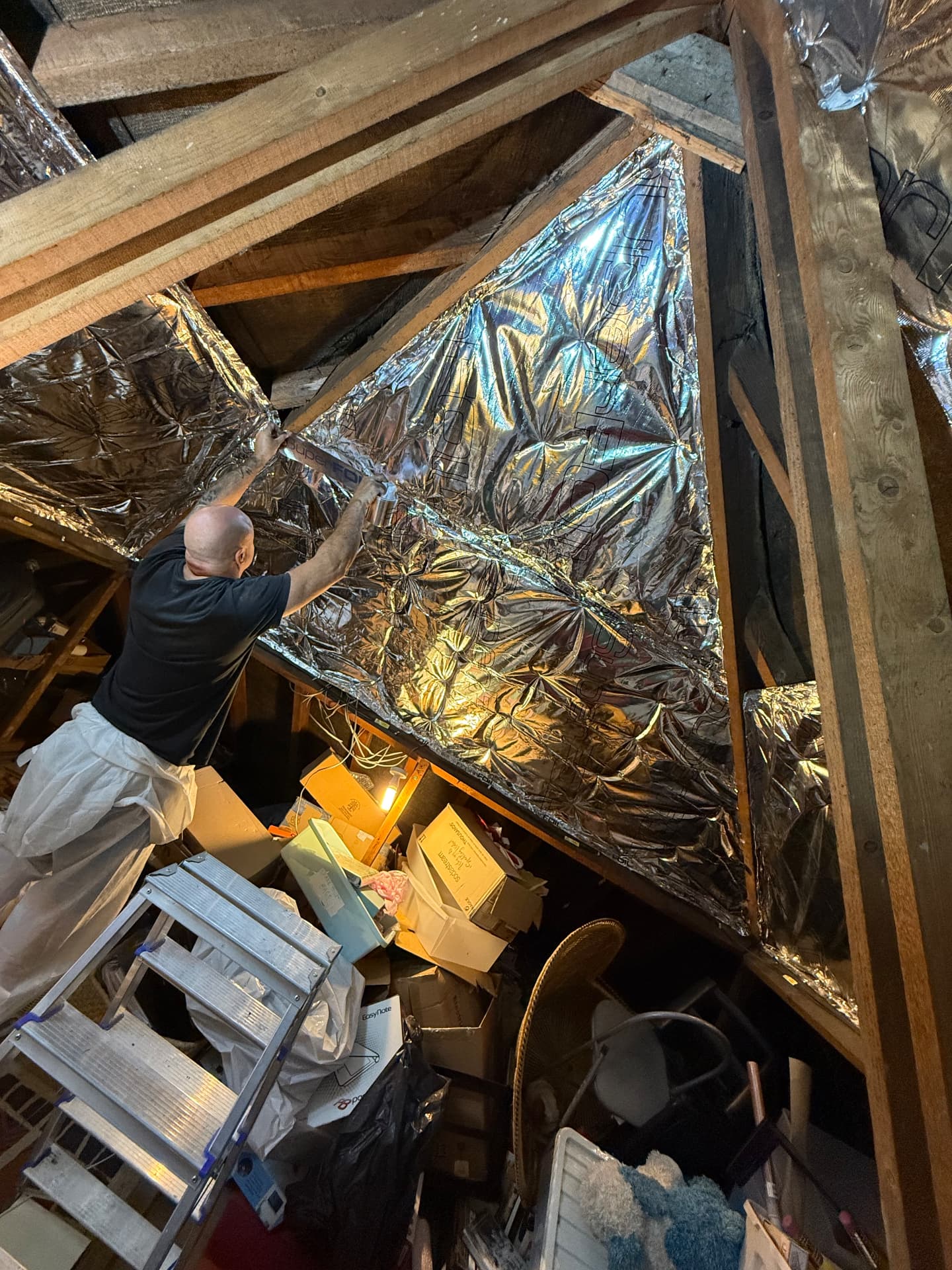 LoftServ Energy installer fitting SuperFOIL SF19+ multifoil insulation to the loft roof slope during installation