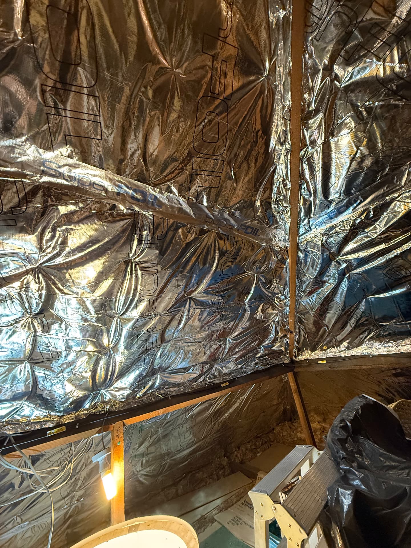 Completed SuperFOIL SF19+ multifoil insulation covering the loft roof slope, joints taped, after installation by LoftServ Energy